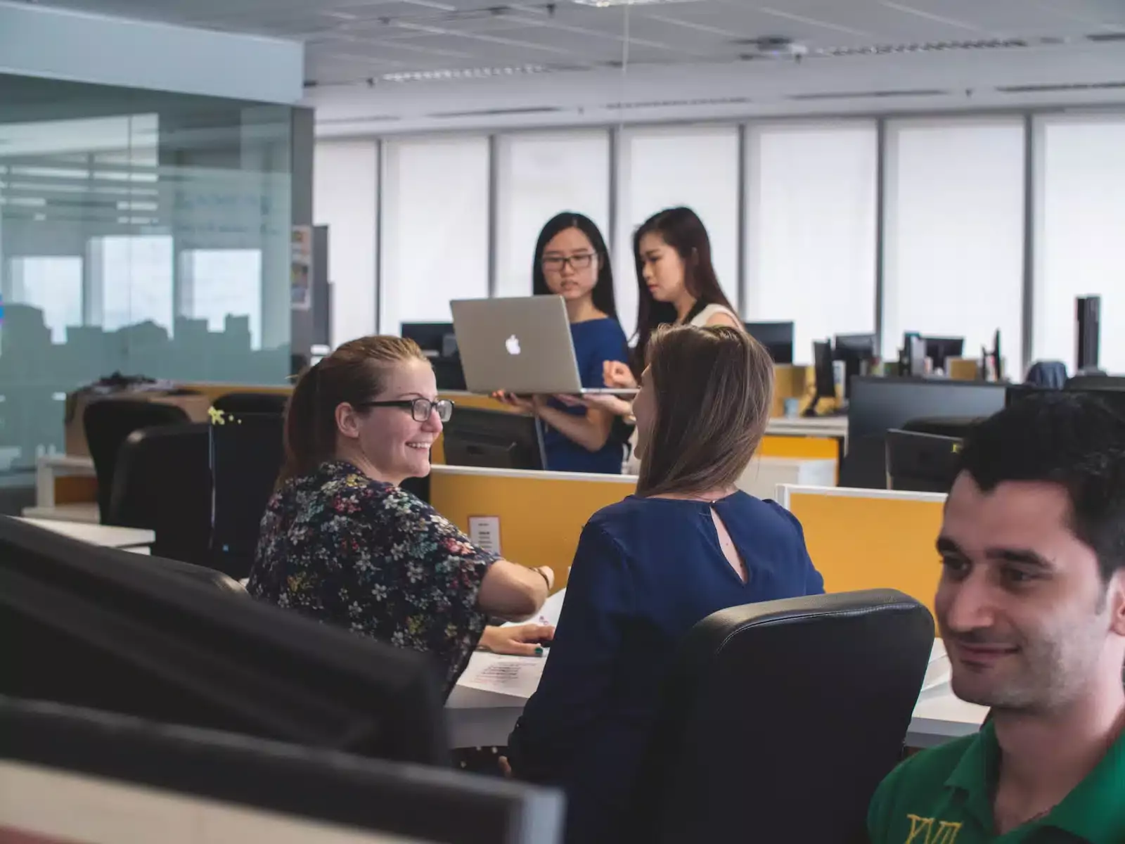 people working together at laptops in an office